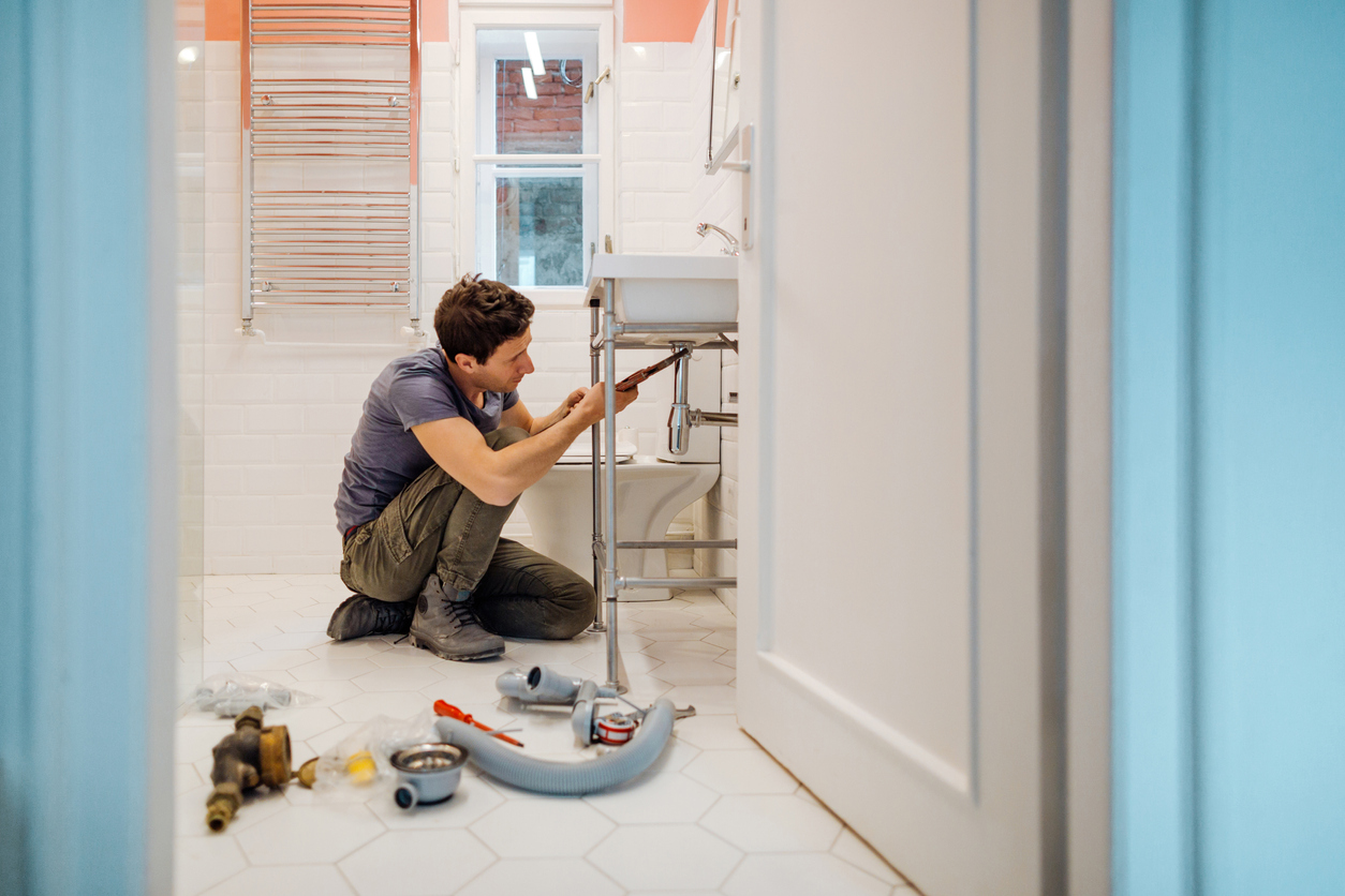 a plumber fixing plumbing damage that is covered by insurance